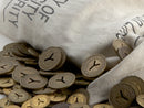 image displaying pile of new york transit tokens spilling from a canvas token transfer bag