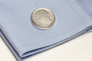 italian lira coin cuff link on a blue sleeve.
