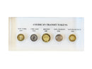 image displaying lucite block featuring five vintage american city transit tokens from new york, chicago, boston, los angeles, and san francisco. front view.