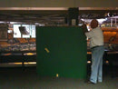 image displaying bob rutko, head of sports memorabilia at td garden, in 2010 holding one of the green panels of the td garden parquet floor.