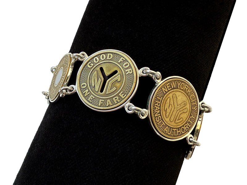 image displaying 5 new york transit token bracelet set in sterling silver bezels on a black background.