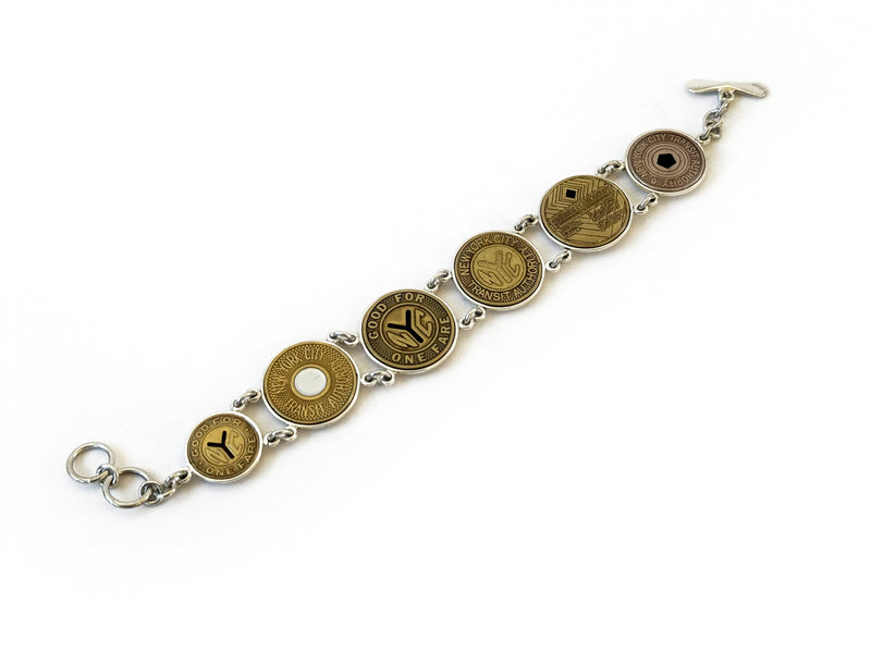 image displaying 5 new york transit token bracelet set in sterling silver bezels.