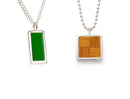 two pendants, one is rectangular and features the green basketball court in a silver bezel. the other is square shaped and features the brown parquet pattern in a silver bezel. both are on silver ball chains.