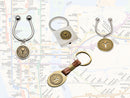 image displaying 4 different key ring styles on new york subway map background